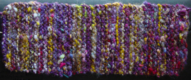 Handspun art yarn knitted into a garter stitch rectangle