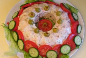 Jellied chicken salad garnished with tomato and cucumber
