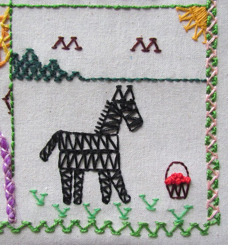An embroidered chevron stitch zebra eating apples.