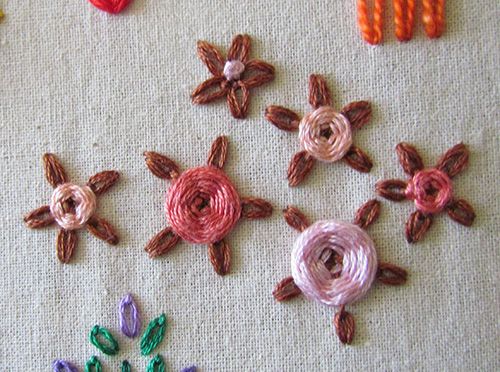 Long tack chain stitch flowers with woven and french knot centres.