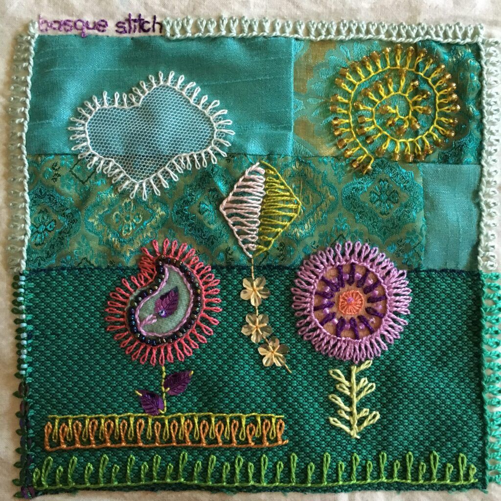 Embroidery sampler with flowers and a kite on a patchwork background.