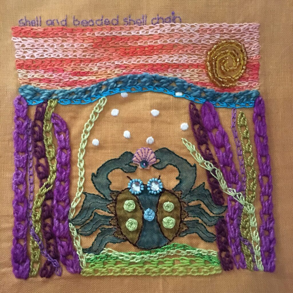 Embroidery sampler featuring a crab sitting on the ocean floor. Featuring shell chain and beaded shell chain stitches.