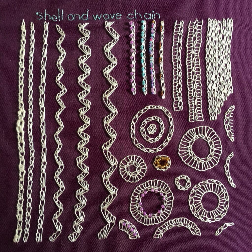 Embroidery in white thread on a vintage purple serviette.