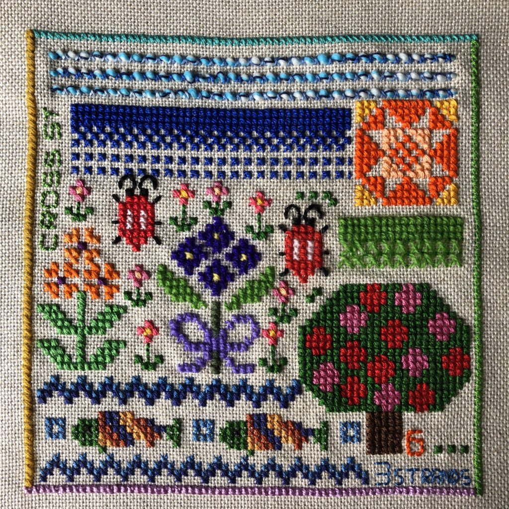 Counted cross stitch sampler worked with a variety of threads.