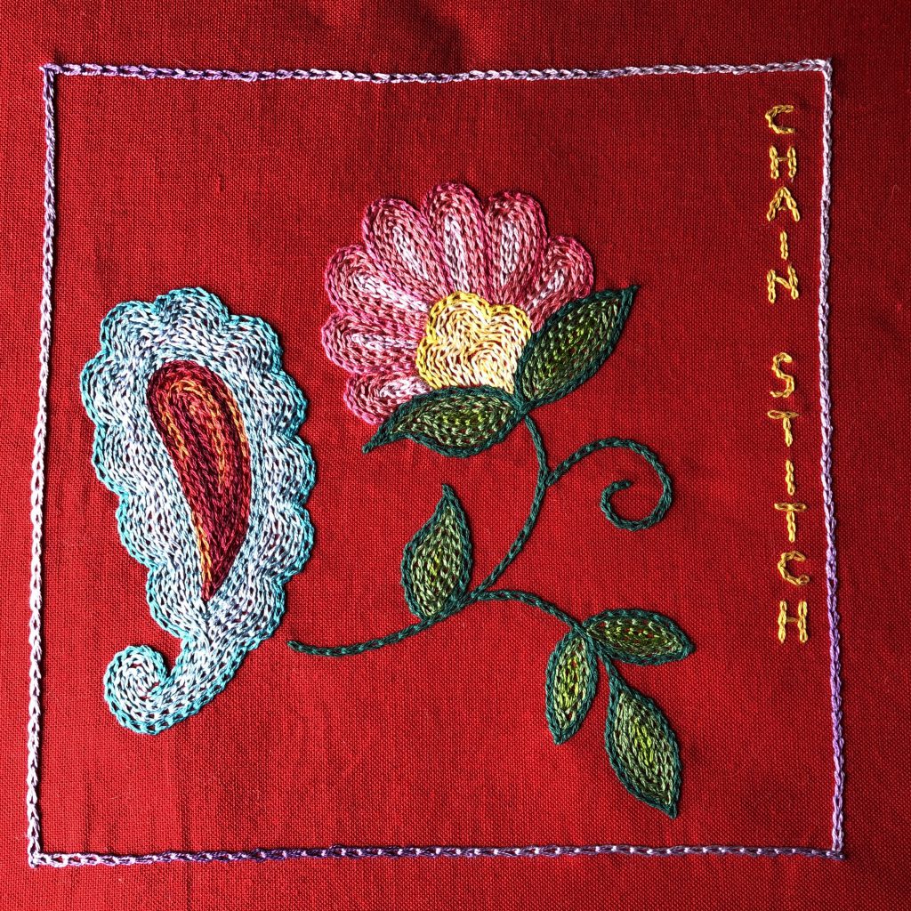 Flower and paisley embroidered with chain stitch filling.