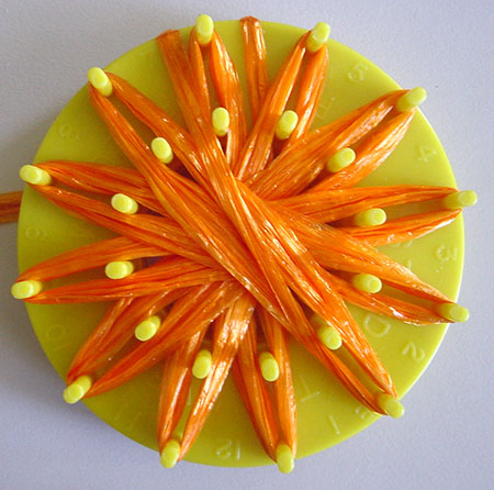 Orange ribbon straw on a multi-fleur loom