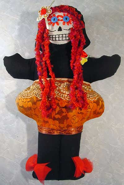 Day of the dead doll with red dreadlocks and skull face