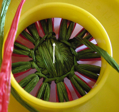 Stitching a strawberry on a flower loom