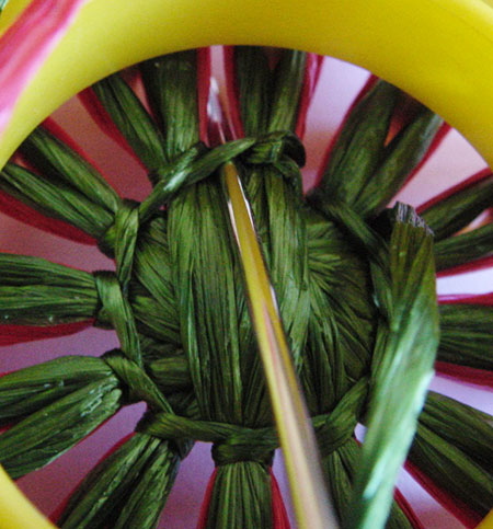 Stitching a strawberry on a flower loom