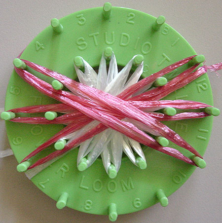 Winding a doll on a flower loom