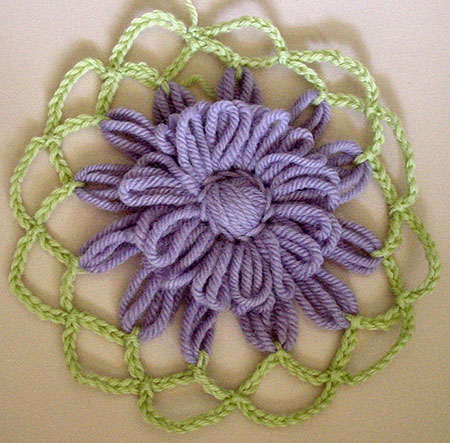 The first loomed flower wih two rounds of crochet