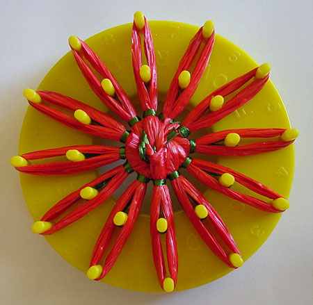 Stitching a strawberry on a flower loom