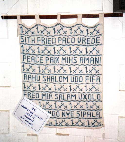 Knitted blanket with the word for eace in many languages