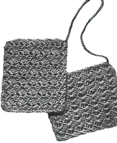 Two shell stitch potholders joined by a chain for picking up large cooking pans