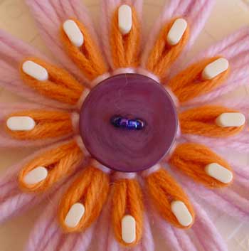 Stitching a button to the center of a loomed flower