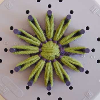 Finished yarn flower in two colors, on the loom