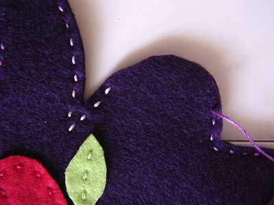 Purple felt doll with seam opening at the side of the skirt