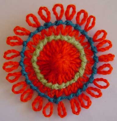 A loomed flower decorated with knot stitch