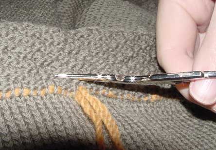 Cutting the stitches a row or two above the stitches that have been threaded onto yarn.