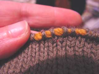 Live stitches threaded onto yarn, ready to place onto the knitting needles.