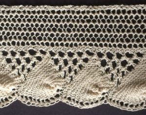 Wide knitted shell lace with eyelet triangles