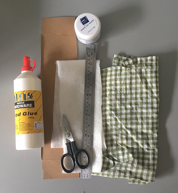 Glue, scissors, ruler, paintbrush, paint, cardboard, wadding and green gingham