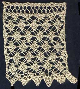 Wide knitted edging with torchon lace pattern