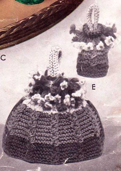 Knitted egg and tea cozies with cabled patterning in the shape of a basket of flowers