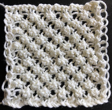 A knit swatch of arachne stitch