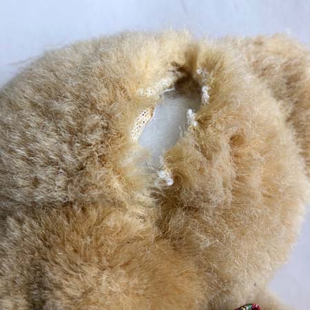 Teddy bear with a seam cut open on the head.