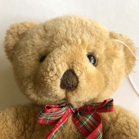 Teddy bear with a new eye and partially sewn seam.