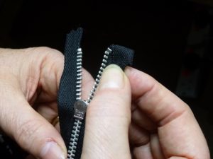 Hands opening a zipper
