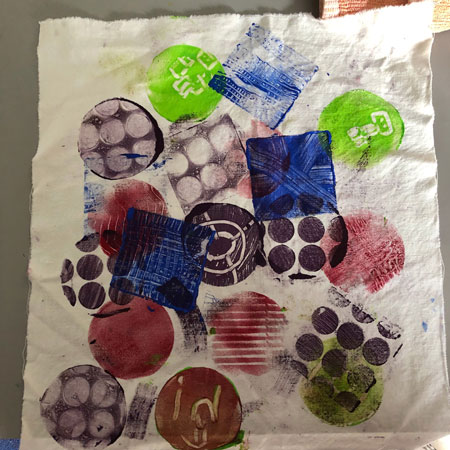 Gelli printed fabric with a random design of squares and circles.