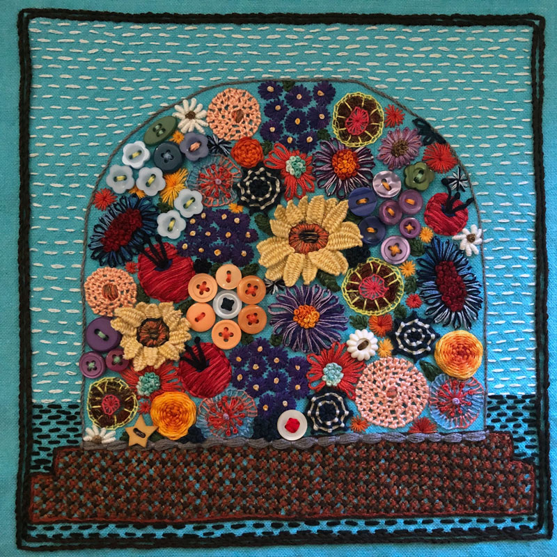 Embroidered sampler of a glass dome filled with flowers