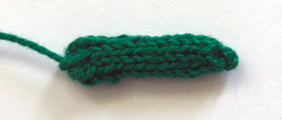 A tiny, green knitted tube
