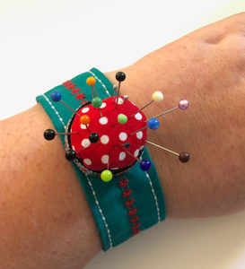 A pincushion on a strap to wear around your wrist
