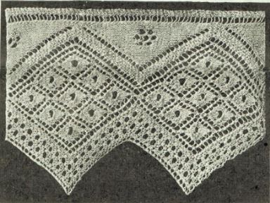 A wide, knitted sawtooth edge lace edging with a series of 9 lace diamonds set inside a large diamond. 