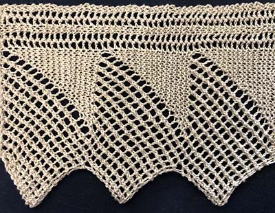 Wide knitted sample of a pointed lace edging.