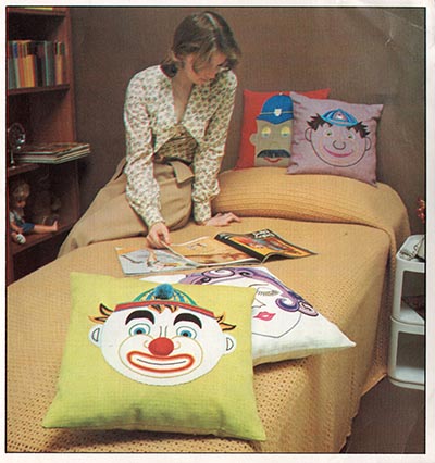 Four hand embroidered cushions with cartoon faces. 1974.