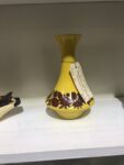 A yellow posy vase with burgundy floral design