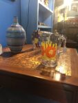 Vintage juice glass with yellow stripes and a bold orange flower