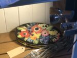 A black plate with brightly coloured flowers painted on it